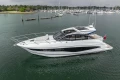 2025 Princess V50 yacht on calm water, surrounded by marina and boats.