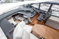 Luxurious 2025 Princess V50 yacht interior with modern helm, seating, and wooden finishes.