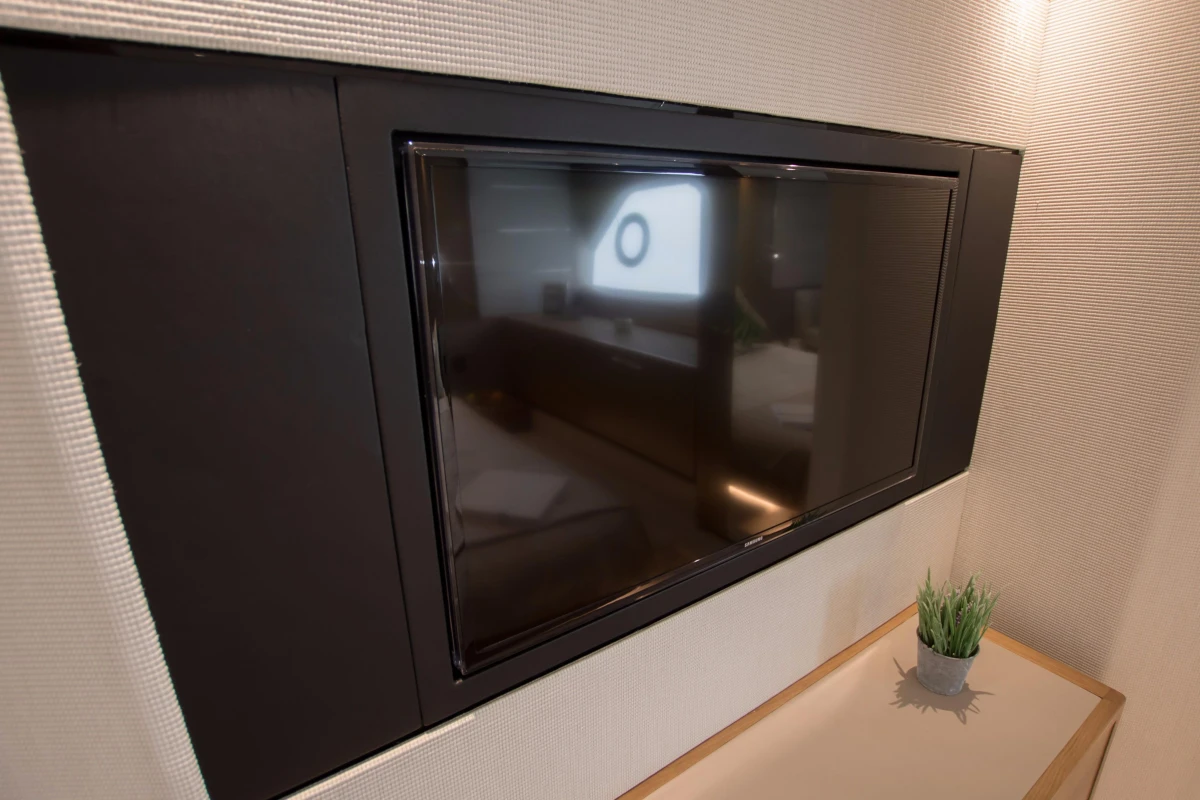 Flat-screen TV in 2016 Princess V58 Open yacht interior, with modern decor and small plant.