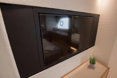 Flat-screen TV in 2016 Princess V58 Open yacht interior, with modern decor and small plant.