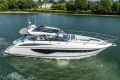 2024 Princess V40 yacht cruising on a serene river with lush greenery.