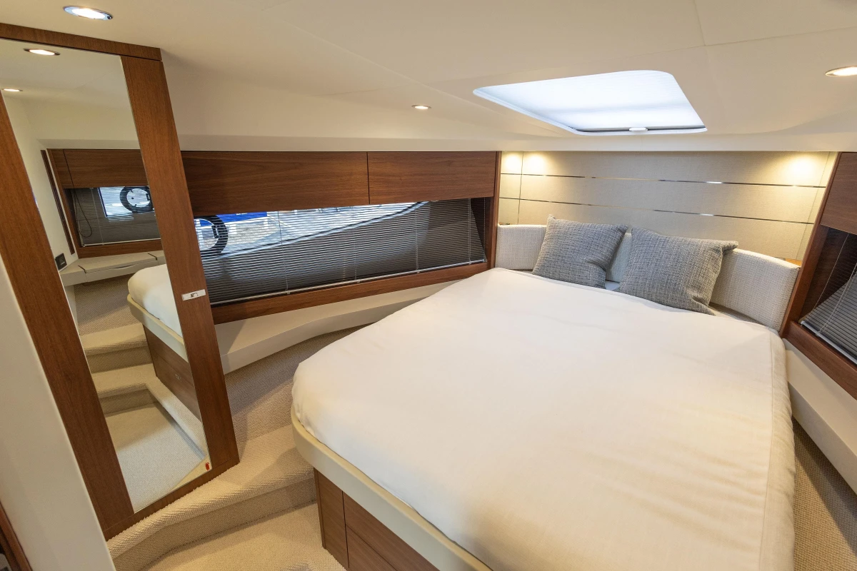 Luxurious 2024 Princess V40 yacht bedroom with modern design and cozy bedding.