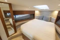 Luxurious 2024 Princess V40 yacht bedroom with modern design and cozy bedding.