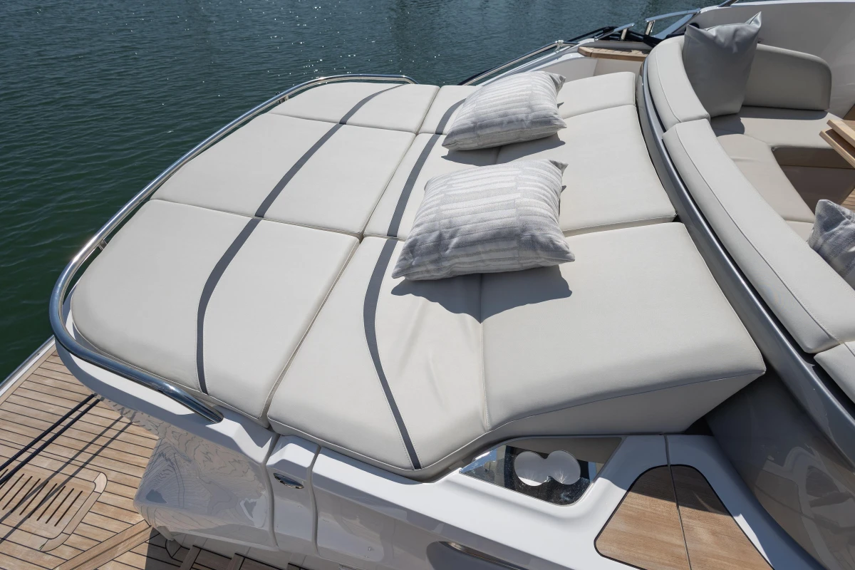 Luxurious sunbathing deck on 2025 Princess S65 yacht with plush cushions and serene water view.