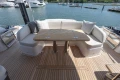 Luxurious seating area on 2025 Princess S65 yacht with wooden deck and scenic marina view.