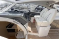 Interior of 2018 Princess V40 yacht with helm, white seats, and wooden flooring.