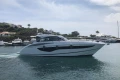 2022 Princess V40 yacht cruising in a scenic harbor with lush greenery.
