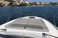 2022 Princess V40 yacht with sunbathing deck, cruising near coastal homes and marina.