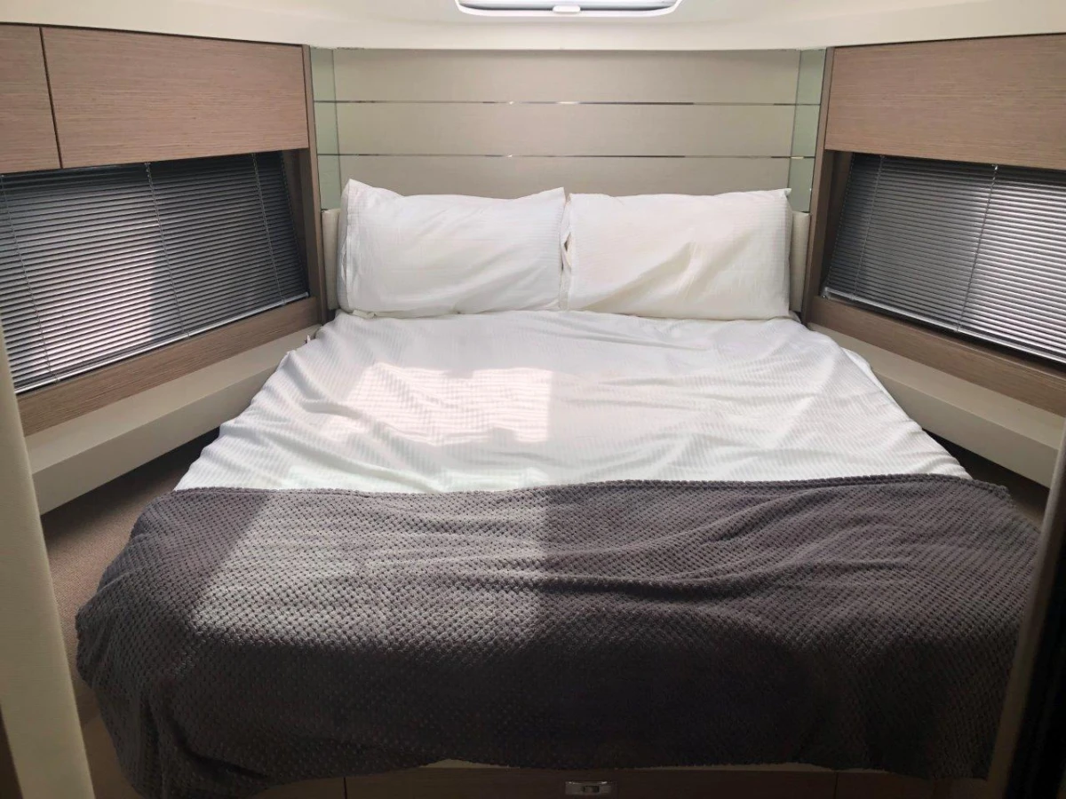 Luxurious 2022 Princess V40 yacht cabin with cozy bed and modern design.
