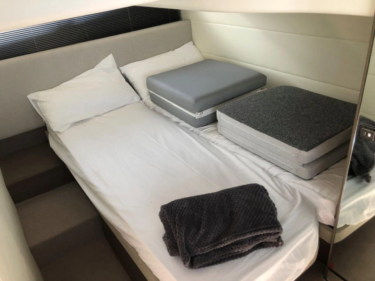 2022 Princess V40 yacht cabin with bed, cushions, and folded blanket.
