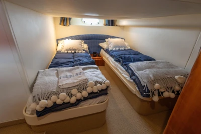 Twin cabin in 2000 Princess V42 yacht with cozy bedding and nautical decor.