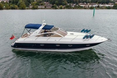 2000 Princess V42 yacht on calm water, featuring sleek design and blue canopy.