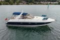 2000 Princess V42 yacht on calm water, featuring sleek design and blue canopy.