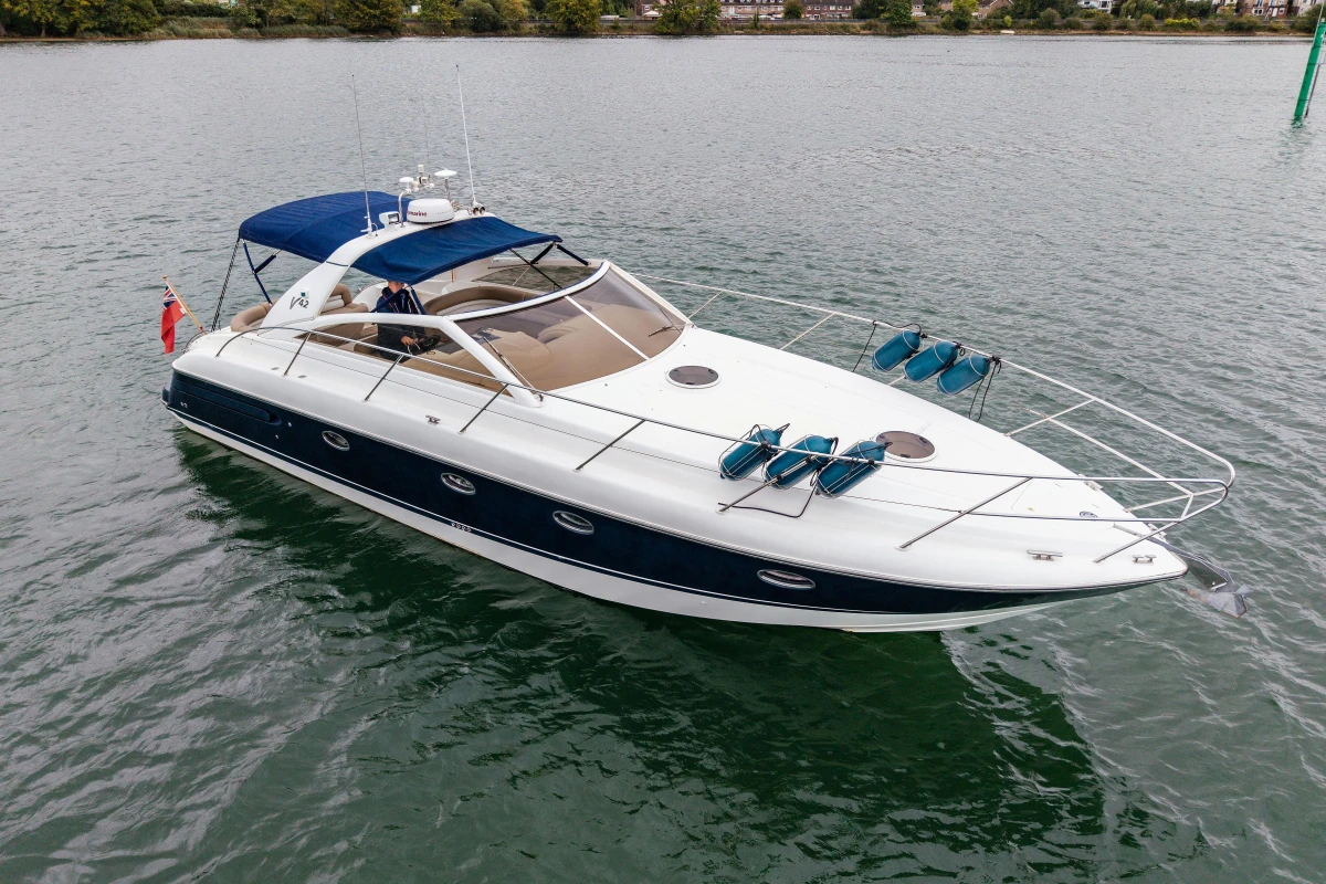 2000 Princess V42 yacht on water, featuring sleek design and blue canopy.