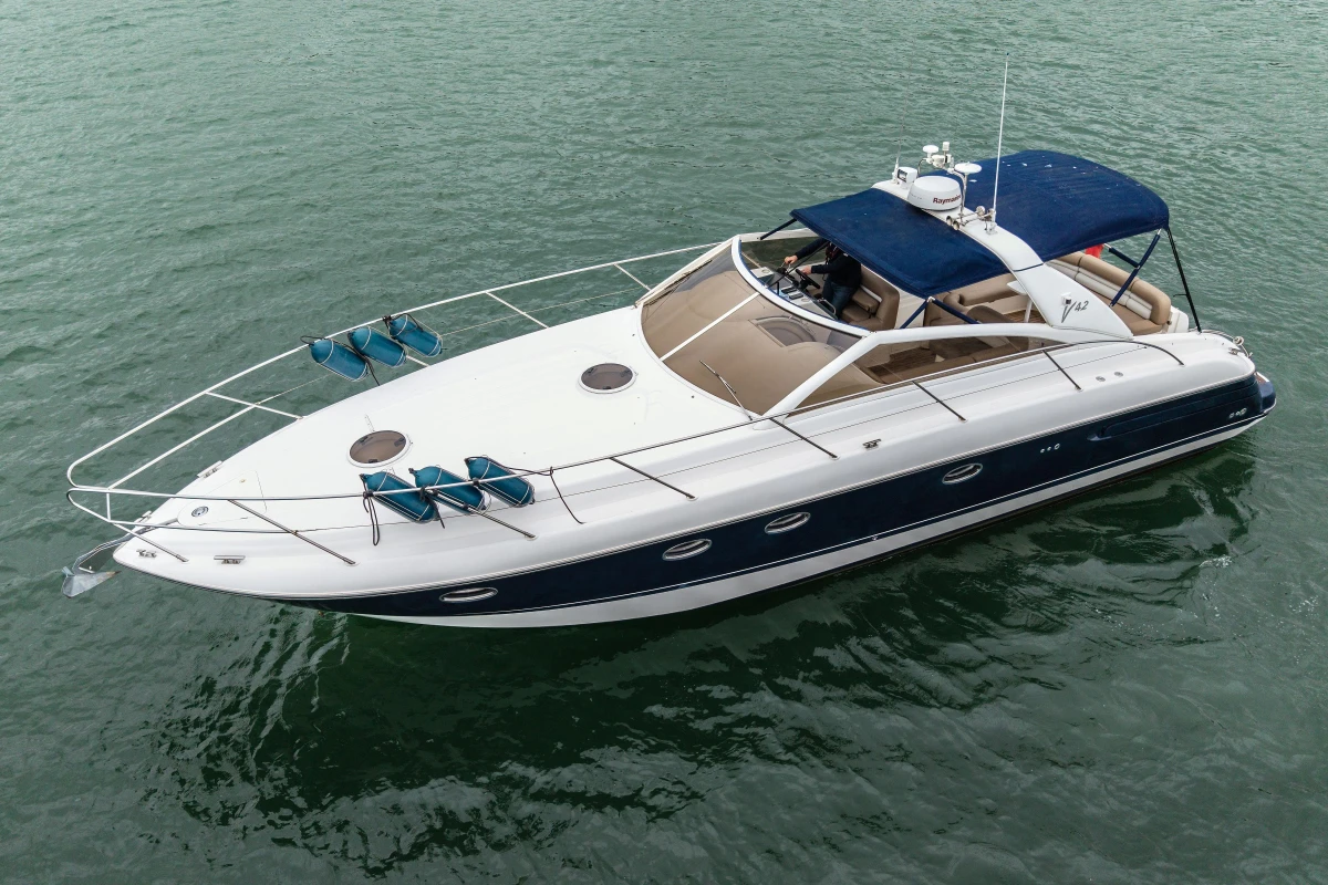 Luxury 2000 Princess V42 yacht cruising on calm waters, featuring sleek design and spacious deck.