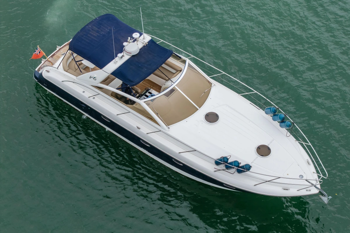 2000 Princess V42 yacht with blue canopy cruising on calm waters.