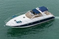 2000 Princess V42 yacht cruising on calm green waters, featuring sleek design and blue canopy.