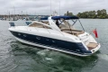 2000 Princess V42 yacht cruising in a marina, featuring sleek design and British flag.