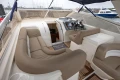 Luxurious interior of 2000 Princess V42 yacht with beige seating and modern controls.