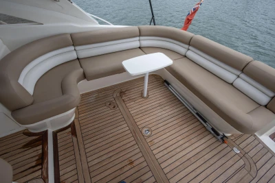 Luxurious seating area on 2000 Princess V42 yacht with teak deck and table.