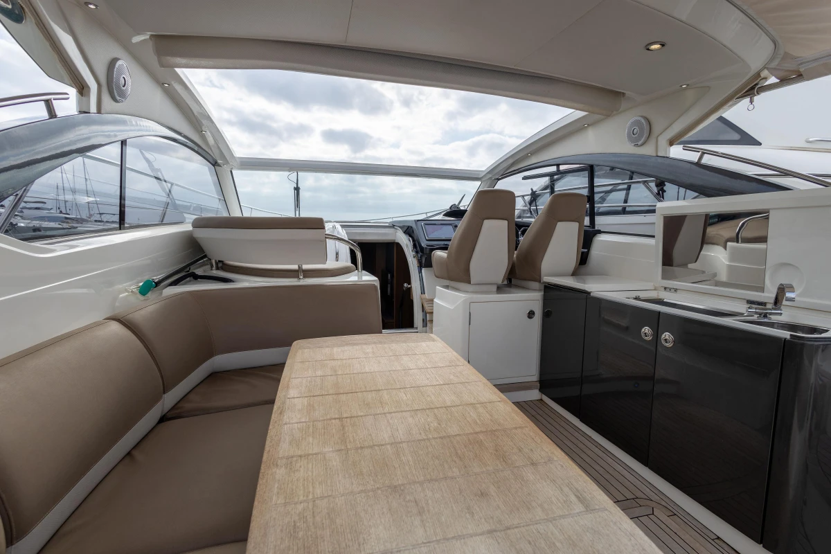 Luxurious interior of 2014 Princess V39 yacht with seating and kitchenette.