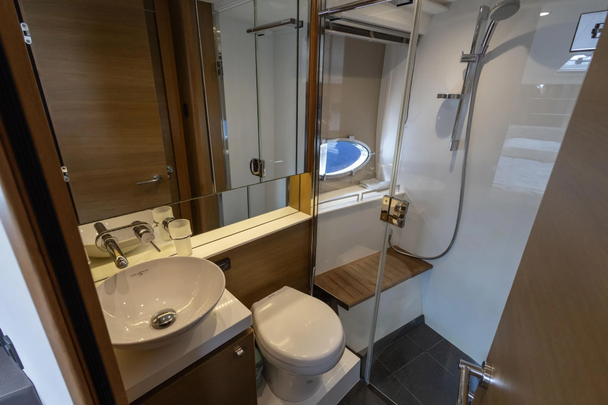 Luxurious bathroom in 2014 Princess V39 yacht with modern fixtures and porthole window.