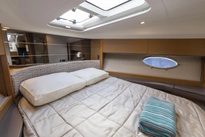 Luxurious cabin interior of 2014 Princess V39 yacht with bed and porthole.