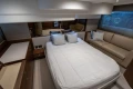 Luxurious bedroom interior of 2017 Princess 49 yacht with bed, sofa, and elegant decor.