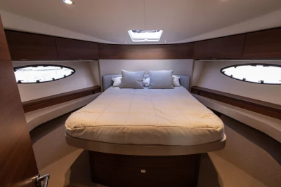 Luxurious bedroom interior of 2017 Princess 49 yacht with elegant wood finishes.