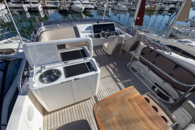 Luxurious 2017 Princess 49 yacht deck with seating, grill, and sink in marina.
