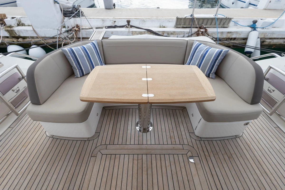 Luxurious seating area on 2017 Princess 49 yacht with wooden table and striped cushions.