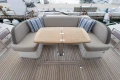 Luxurious seating area on 2017 Princess 49 yacht with wooden table and striped cushions.