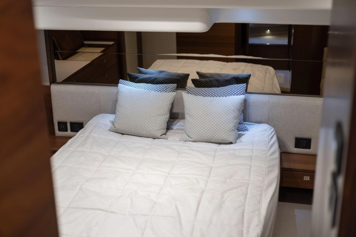 Luxurious bedroom interior of 2017 Princess 49 yacht with elegant bedding and cushions.