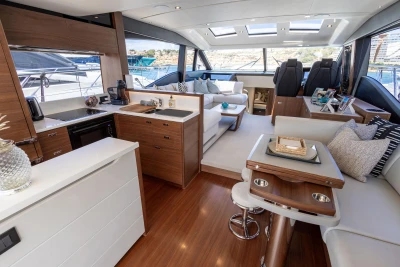 Luxurious interior of 2022 Princess S66 yacht with modern kitchen and seating area.