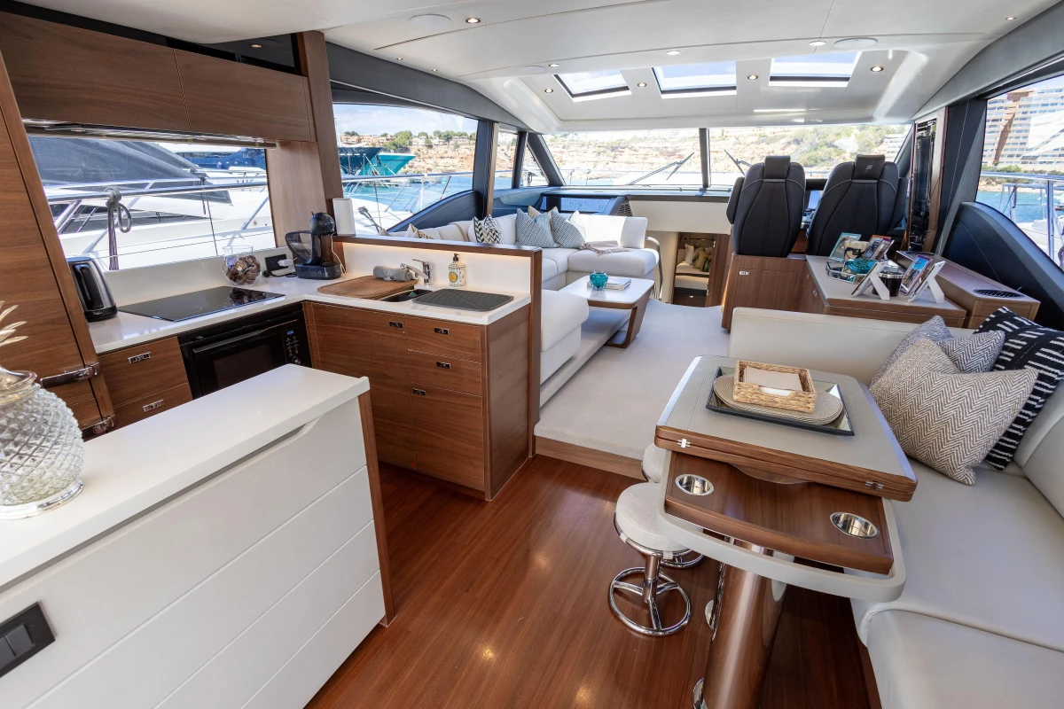 Luxurious interior of 2022 Princess S66 yacht with modern kitchen and seating area.
