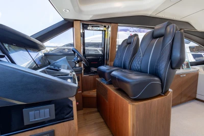 Luxurious interior of 2022 Princess S66 yacht with leather seating and modern helm.