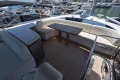 Luxurious 2023 Princess S62 yacht deck with seating and table, docked at marina.