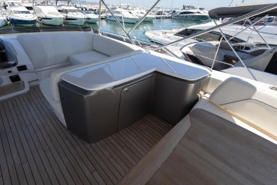 Luxurious 2023 Princess S62 yacht deck with seating and storage, docked at marina.