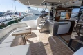 Luxurious 2023 Princess S62 yacht deck with seating, table, and staircase in a marina setting.