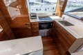 Luxurious kitchen interior of 2023 Princess S62 yacht with modern appliances and wood finish.