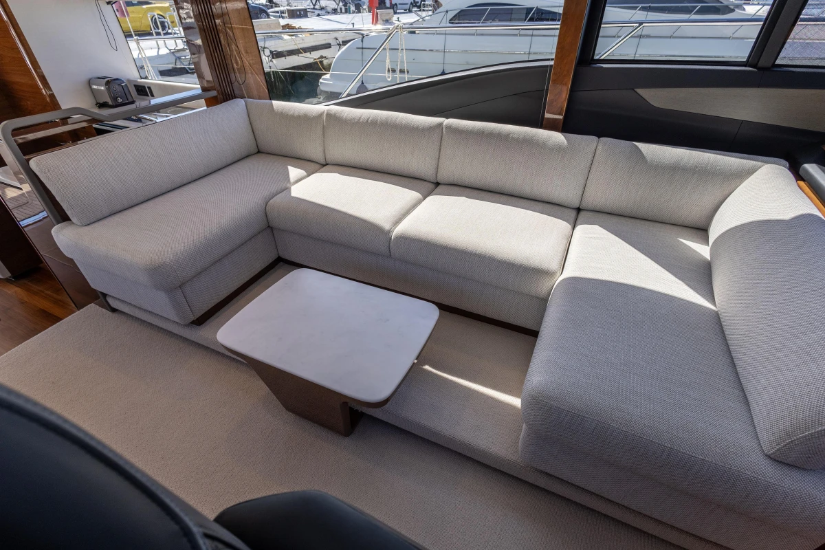 Luxurious interior of 2023 Princess S62 yacht with elegant beige sofa and modern table.