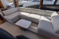 Luxurious interior of 2023 Princess S62 yacht with elegant beige sofa and modern table.