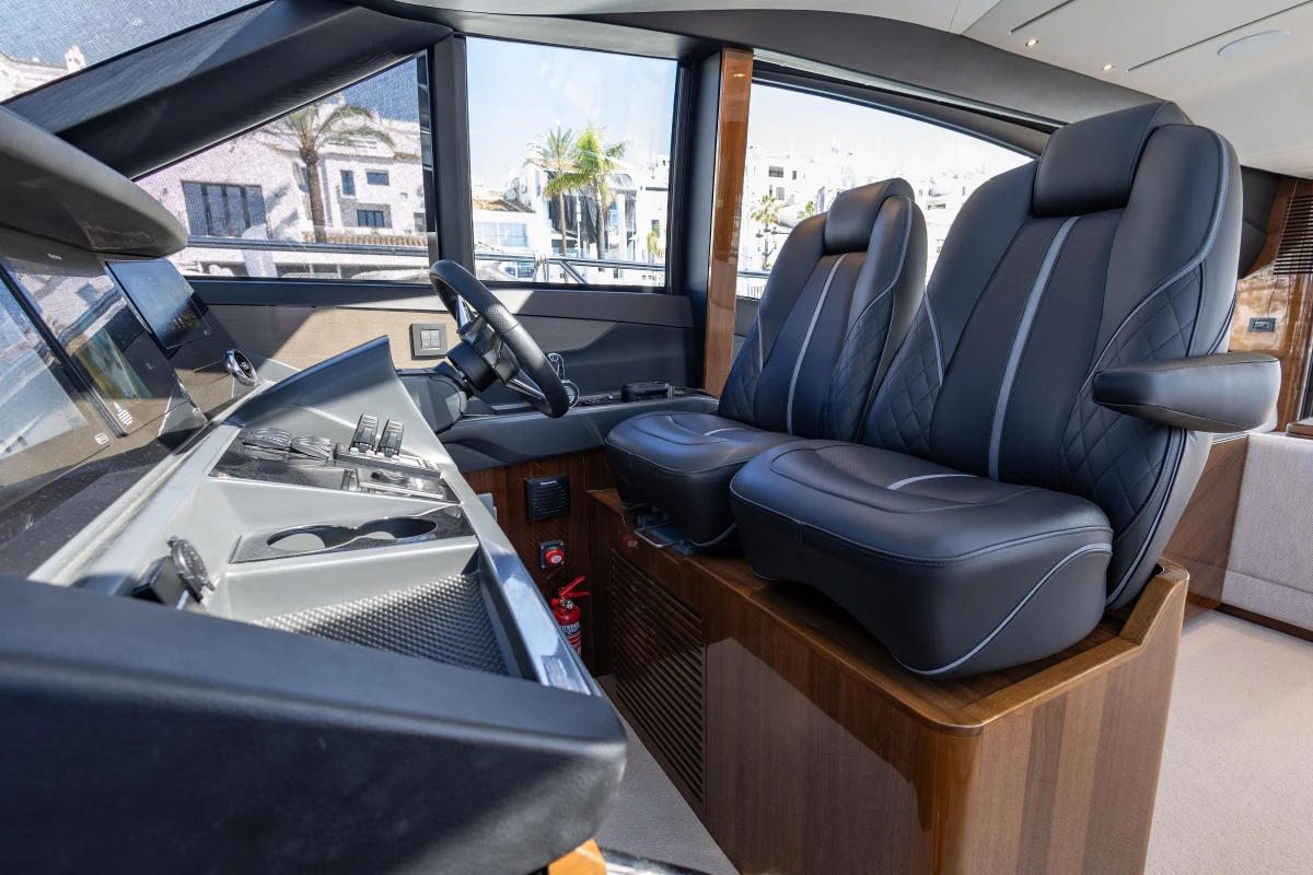 Luxurious interior of 2023 Princess S62 yacht with sleek black seating and modern controls.