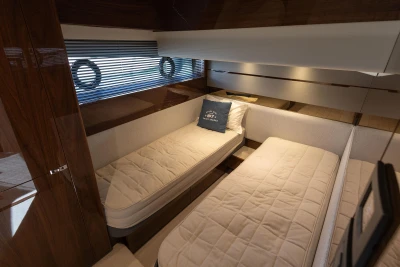Luxurious twin cabin interior of 2023 Princess S62 yacht with elegant bedding and wood finishes.