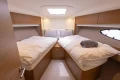 Luxurious cabin interior of 2017 Princess V48 Open yacht with twin beds and modern decor.