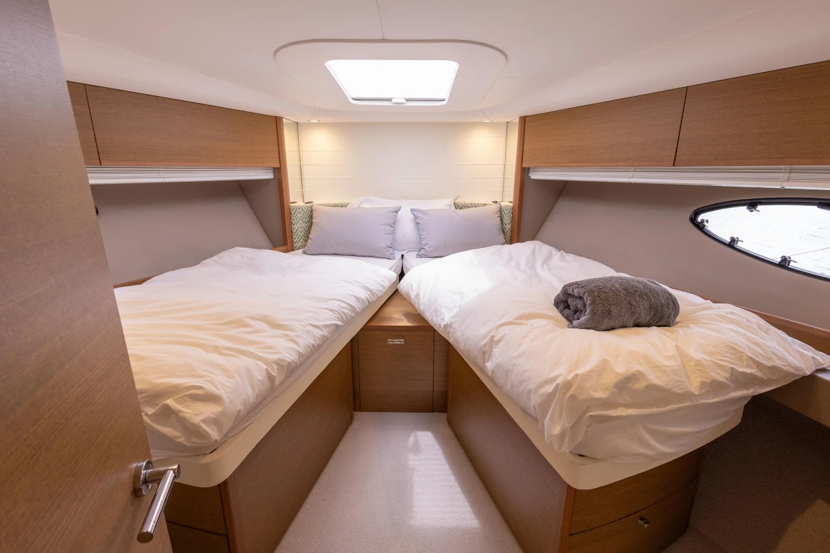 Luxurious cabin interior of 2017 Princess V48 Open yacht with twin beds and modern decor.