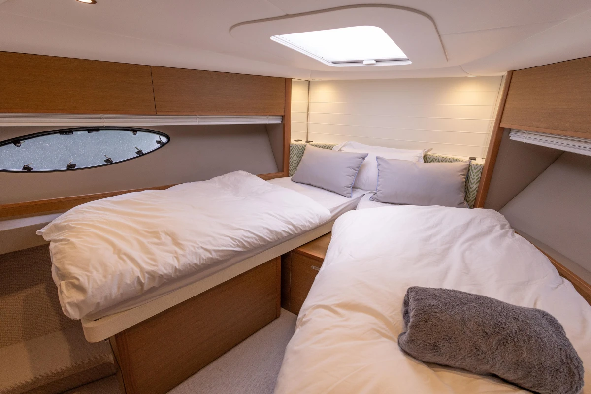 Luxurious cabin interior of 2017 Princess V48 Open yacht with cozy bedding.