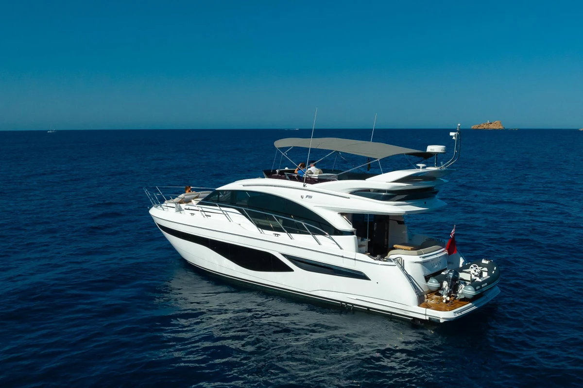 2023 Princess F55 yacht cruising on open blue sea under clear sky.