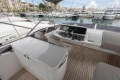 Luxurious 2023 Princess F55 yacht cockpit with modern controls, docked in a marina.