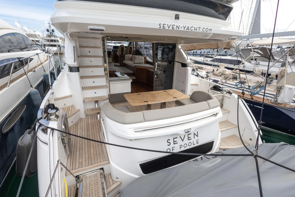 Luxury Princess F55 yacht, 2023 model, docked with elegant seating and dining area.